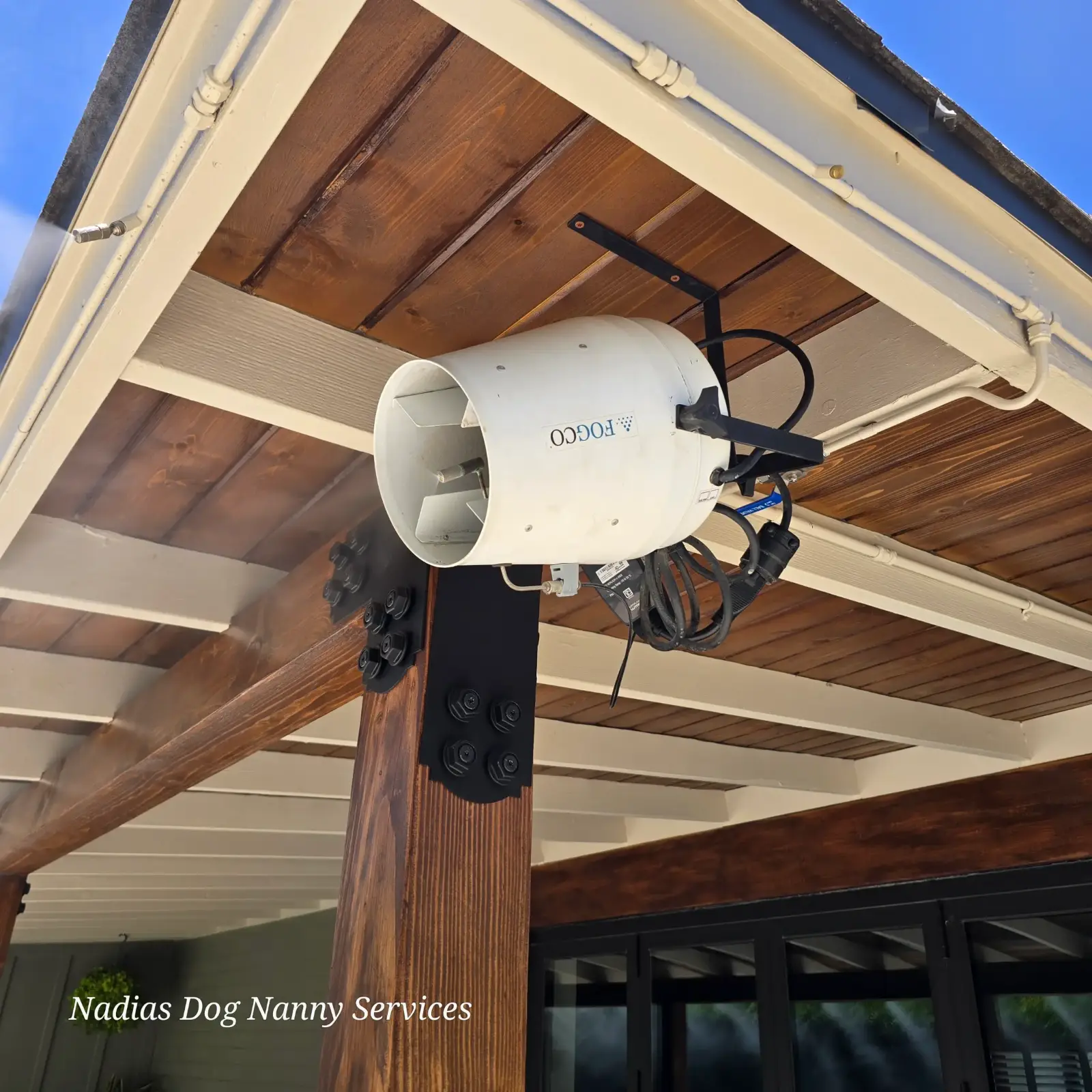 A misting fan mounted under the patio roof to keep dogs cool through the Phoenix summer